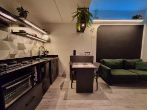 uma cozinha com um sofá e uma mesa em Studio Praia de Botafogo no Rio de Janeiro