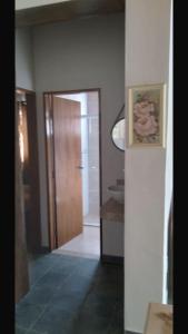 a hallway of a bathroom with a door and a sink at Chalé Aconchegante in Passa Quatro +1 photo