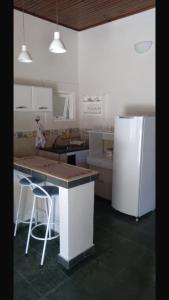 a kitchen with a counter and a refrigerator in it at Chalé Aconchegante in Passa Quatro