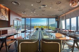 a restaurant with tables and chairs and large windows at FAV LUX Kagoshima Tenmonkan in Kagoshima