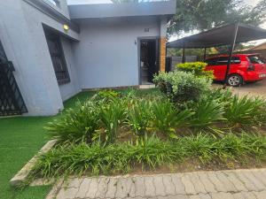 a red car parked in front of a house at Yello Guest House in Vanderbijlpark +5 photos