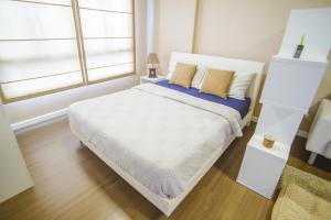 a bedroom with a white bed and a window at Baan Thew Lom @ Sea in Cha Am +14 photos