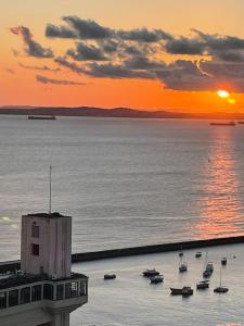 a sunset over a body of water with boats at Apartamento vista ao mar com ar in Salvador