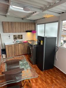 a kitchen with a black refrigerator and a stove at Apartamento Barrio la Argentina vía principal 302 in Manizales