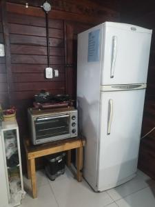 a kitchen with a refrigerator and a microwave at Cabaña Madreselva in Colonia Benítez