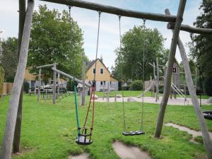 an empty playground with swings in a park at Holiday Home in Zeeland near Beaches in Wemeldinge