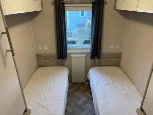 HippolytushoefにあるCharming chalet with spacious enclosed gardenの窓のある小さな部屋にベッドが2つある