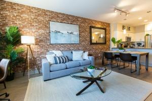 a living room with a blue couch and a brick wall at 3 Miles to Disney Heated Pool CnvntnCtr Jacuzzi in Fullerton