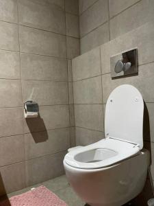 a bathroom with a toilet and a pink rug at Luxury Cantonments Henriettas 1-bedroom apartment in Accra - FiveHills homes in Accra