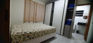 Un dormitorio pequeño con una cama y un espejo. en Bela Mar Mongaguá, en Mongaguá 14 fotos más