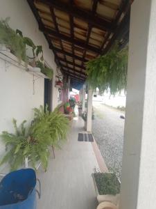 un porche con macetas al lado de un edificio en Residencial Roseleia, en Penha