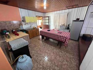 a kitchen with a table in the middle of a room at Casa Tangerina - Lago Pinhal in Rio dos Cedros