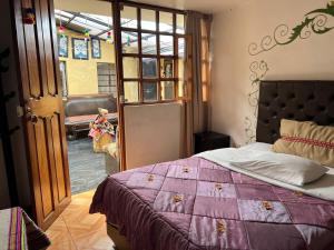 una camera con un letto e un piumone viola di Redys House a Cuzco