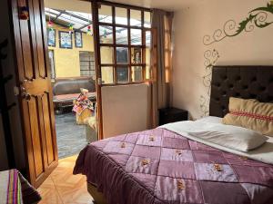 una camera con un letto e un piumone viola di Redys House a Cuzco