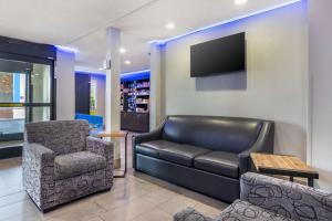 a living room with a leather couch and a chair at Best Western McCarran Inn in Las Vegas