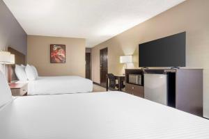 a hotel room with two beds and a flat screen tv at Best Western McCarran Inn in Las Vegas