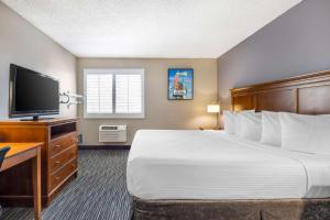 a hotel room with a bed and a flat screen tv at Best Western McCarran Inn in Las Vegas