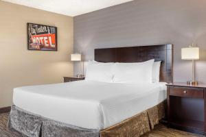 a large bed in a hotel room with two lamps at Best Western McCarran Inn in Las Vegas