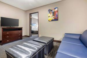 a living room with a couch and a tv at Best Western McCarran Inn in Las Vegas