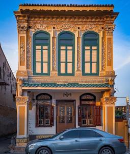 ein blaues Auto, das vor einem Gebäude parkt in der Unterkunft CHCH by LEJU in Malakka