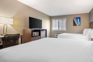 a hotel room with two beds and a flat screen tv at Best Western McCarran Inn in Las Vegas