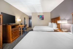 a hotel room with two beds and a flat screen tv at Best Western McCarran Inn in Las Vegas