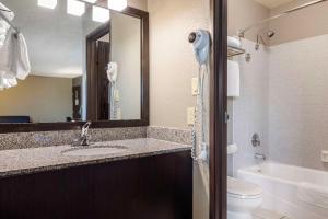 a bathroom with a sink and a toilet and a mirror at Best Western McCarran Inn in Las Vegas