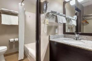 a bathroom with a sink and a toilet and a mirror at Best Western McCarran Inn in Las Vegas