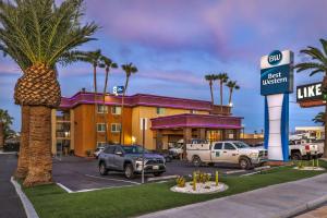 a hotel with cars parked in a parking lot at Best Western McCarran Inn in Las Vegas