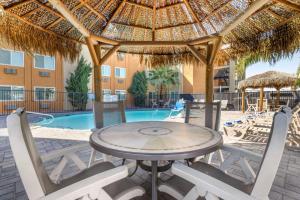 a patio with a table and chairs and a pool at Best Western McCarran Inn in Las Vegas