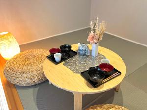 a small wooden table with bowls and vases on it at Koti Sopo Universal Bay 2 by Liaison in Osaka +78 photos