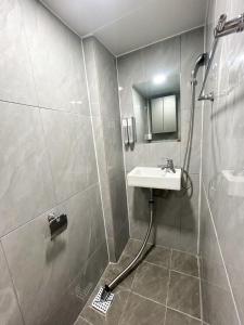 a bathroom with a shower with a sink and a shower at Pocket Seoul Hostel Hongdae in Seoul