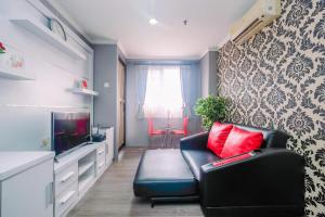 a living room with a couch and a tv at Comfy and New Furnished at 2BR Kebagusan City Apartment By Travelio in Jakarta
