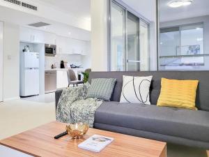a living room with a gray couch and a table at One bedroom Apartment walk to Gordon Train Station in Gordon