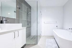 a white bathroom with a tub and a sink and a shower at One bedroom Apartment walk to Gordon Train Station in Gordon
