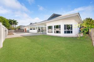 a white house with a green lawn at Majestic Manor 5BR Stylish Super Home - Private Pool - BBQ in Leanyer