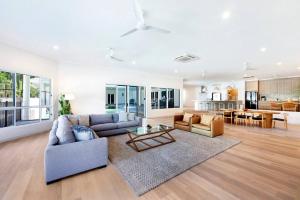 a living room with a couch and a table at Majestic Manor 5BR Stylish Super Home - Private Pool - BBQ in Leanyer