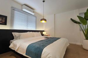 a bedroom with a large bed and a potted plant at 曼谷市中心素坤逸四卧别墅---牛仔街附近 in Bangkok