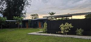 a house with a black fence in a yard at Jorge's Economy Room in Manolo Fortich