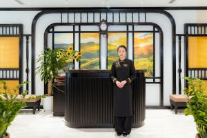 una mujer de uniforme parada frente a un podio en PALAGO BOUTIQUE HOTEL, en Hanói