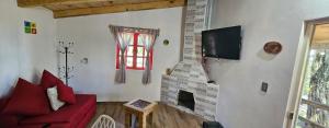 a living room with a red couch and a fireplace at Cabaña Romeo & Juliett in Juanacatlán