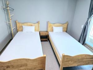 two twin beds in a small room withthritisthritisthritisthritisthritisthritisthritisthritis at Jeonju Hostel in Jeonju