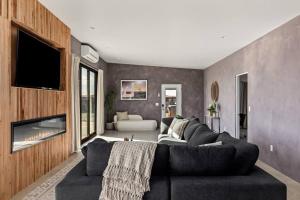 Una sala de estar con un sofá y una chimenea. en Saltwater Pool, Pickleball, Bocce Ball, Glamping, EVcharge, en Joshua Tree