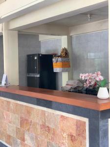 a kitchen with a counter with a refrigerator at Wirana Guest House in Ubud