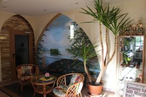 a living room with a table and chairs and a palm tree at Müritz Landhotel Grüner Baum in Gotthun