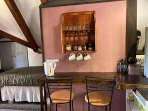 a room with a table and two chairs and a bed at The Chalet Bed and Breakfast-peace and quiet in the country 12 minutes from City in Dunedin