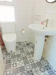 a white bathroom with a sink and a toilet at Beach front B3 Marie Guest house in Jomtien Beach +25 photos