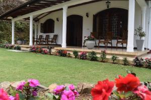 a porch of a house with flowers in the yard at Green Garden Bungalow in Haputale
