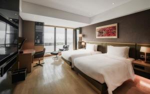 Postelja oz. postelje v sobi nastanitve Grand Metropark Hotel Shanghai Pudong