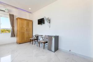 富国Ruby Hotel Phu Quoc的配有桌椅和电视的客厅